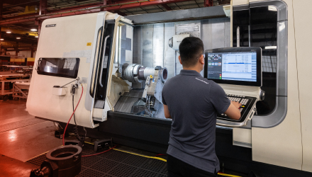 A TAM engineer working at the console of large machine