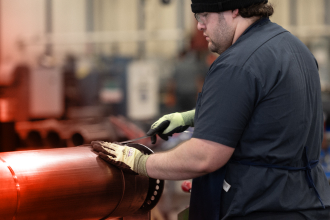 A TAM team member chizeling screw holes to make sure they properly