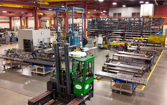 A forklift leaving a room filled with pipes for building packers