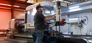 A TAM engineer looking at console, reading results of testing downhole equipment