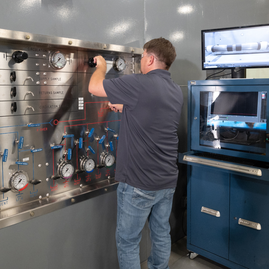 A TAM engineering turning nobs to adjust pressure while testing downhole equipment