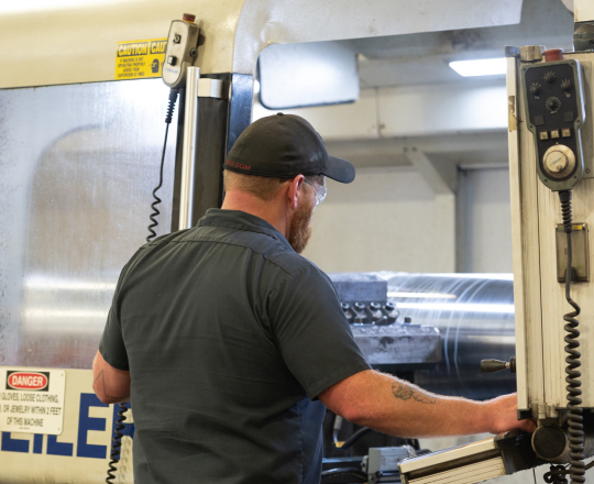 A TAM engineer watching a piece of equipment go through a machine being tested