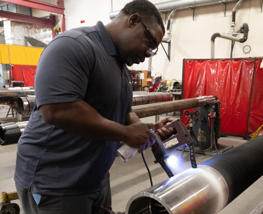 A TAM engineer coating the outside of a pipe