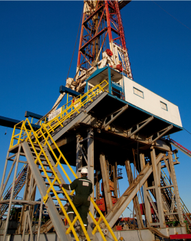 An oil rig worker walking up stairs to the drill tower