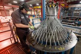 A TAM engineering looking over a large piece of downhole equipment