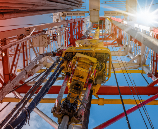 Looking up at oil rig drill shining in the sun