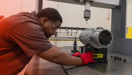 A TAM engineering carefully examining a downhole tool part