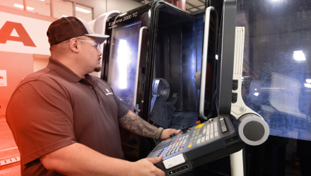 A TAM engineer manning the controls while a packer is tested inside of a machine