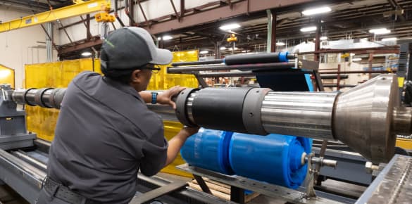 A TAM team member adjusting parts on a downhole packer