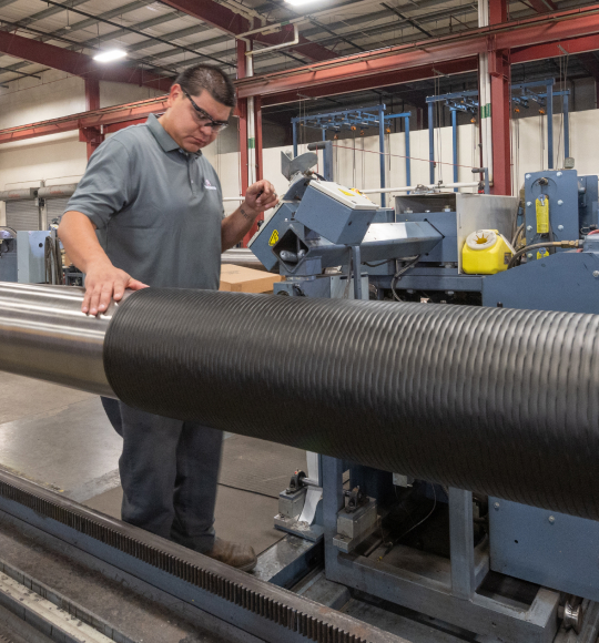 A TAM engineering inspecting the outside casing of a pipe 