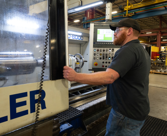 A TAM engineer getting ready to close the door on testing unit to take readings on a packer 