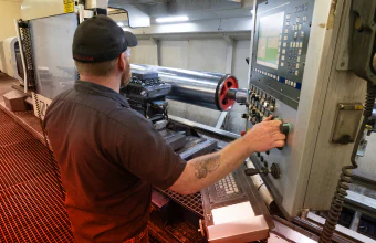 A TAM engineering running a downhole packer through a machine to test it