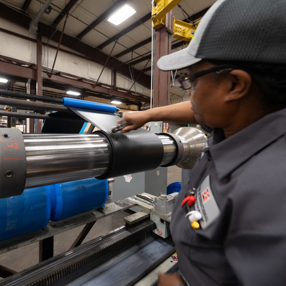 A TAM team member perforating holes in wrappings around packers