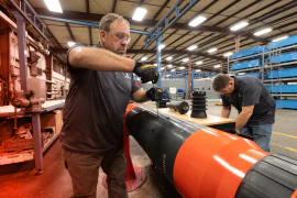 TAM team members working together on an orange packer