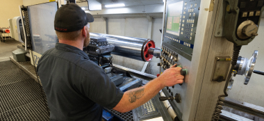 A TAM engineering running a downhole packer through a machine to test it